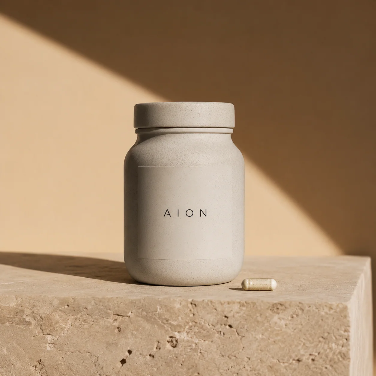 Bote de suplementos AION sobre bloque de travertino