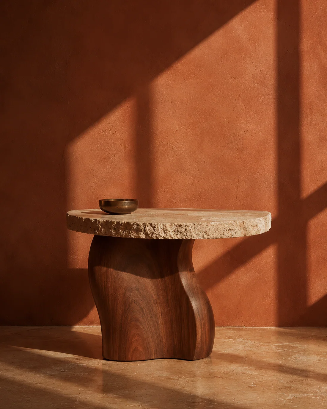 Mesa auxiliar de travertino y nogal sobre pared terracota